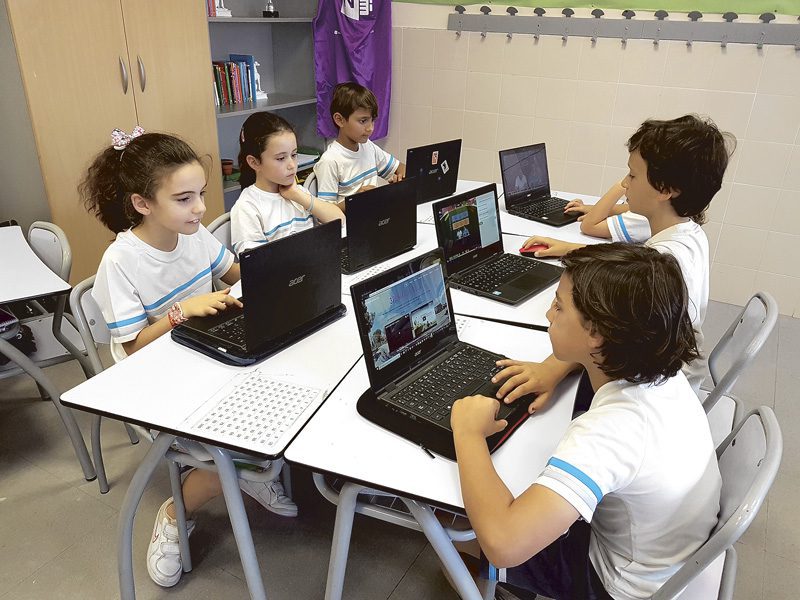 Estudiantes utilizando tecnología en el aula