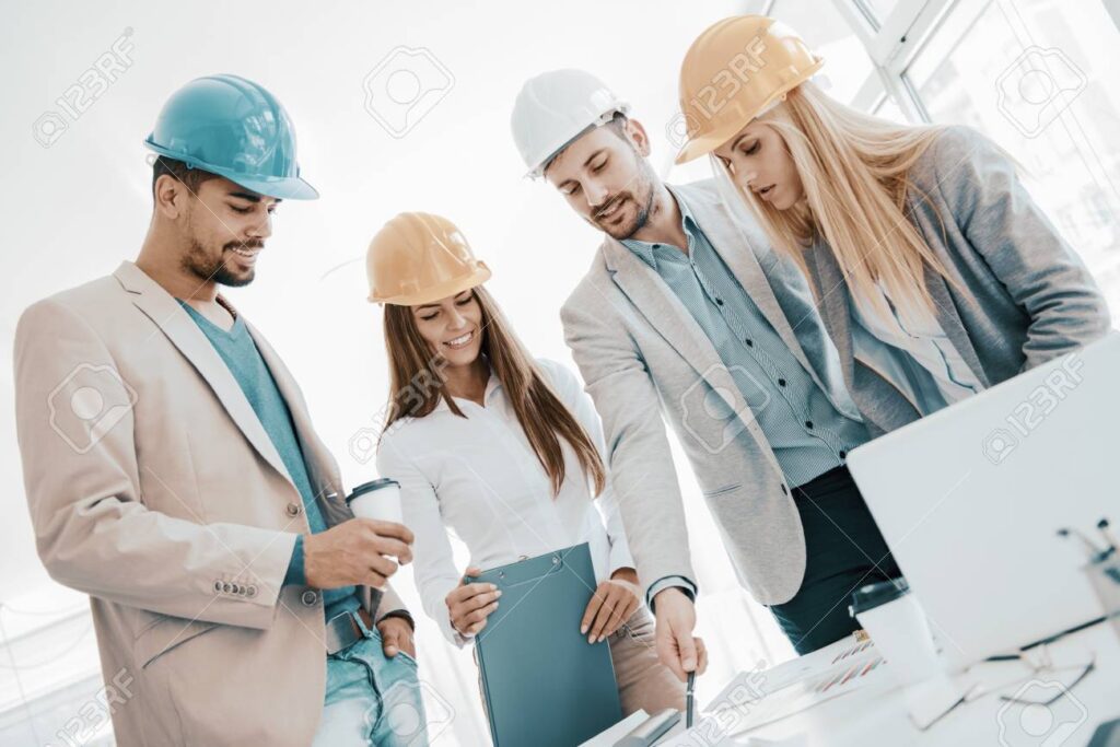 95065867 arquitecto mirando los planos de construccion con trabajadores de la construccion trabajadores de