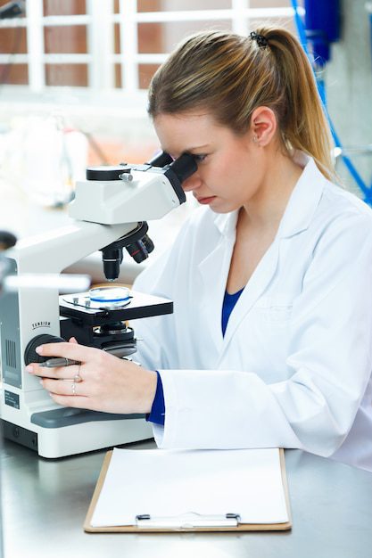 Científico observando microscopio en laboratorio