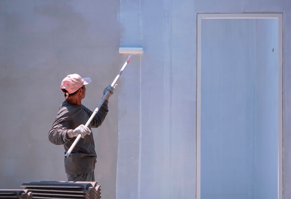 Pintor aplicando pintura en pared